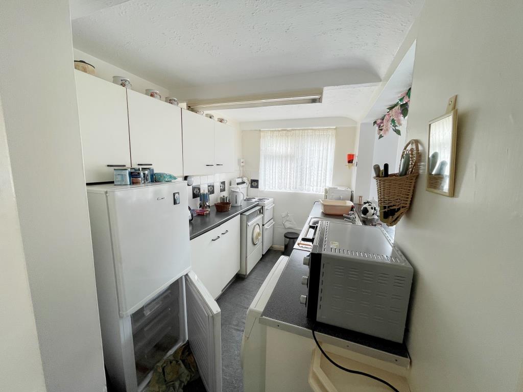 Lot: 63 - TWO-BEDROOM HOUSE FOR REFURBISHMENT - Kitchen with fitted units and opening to dining room